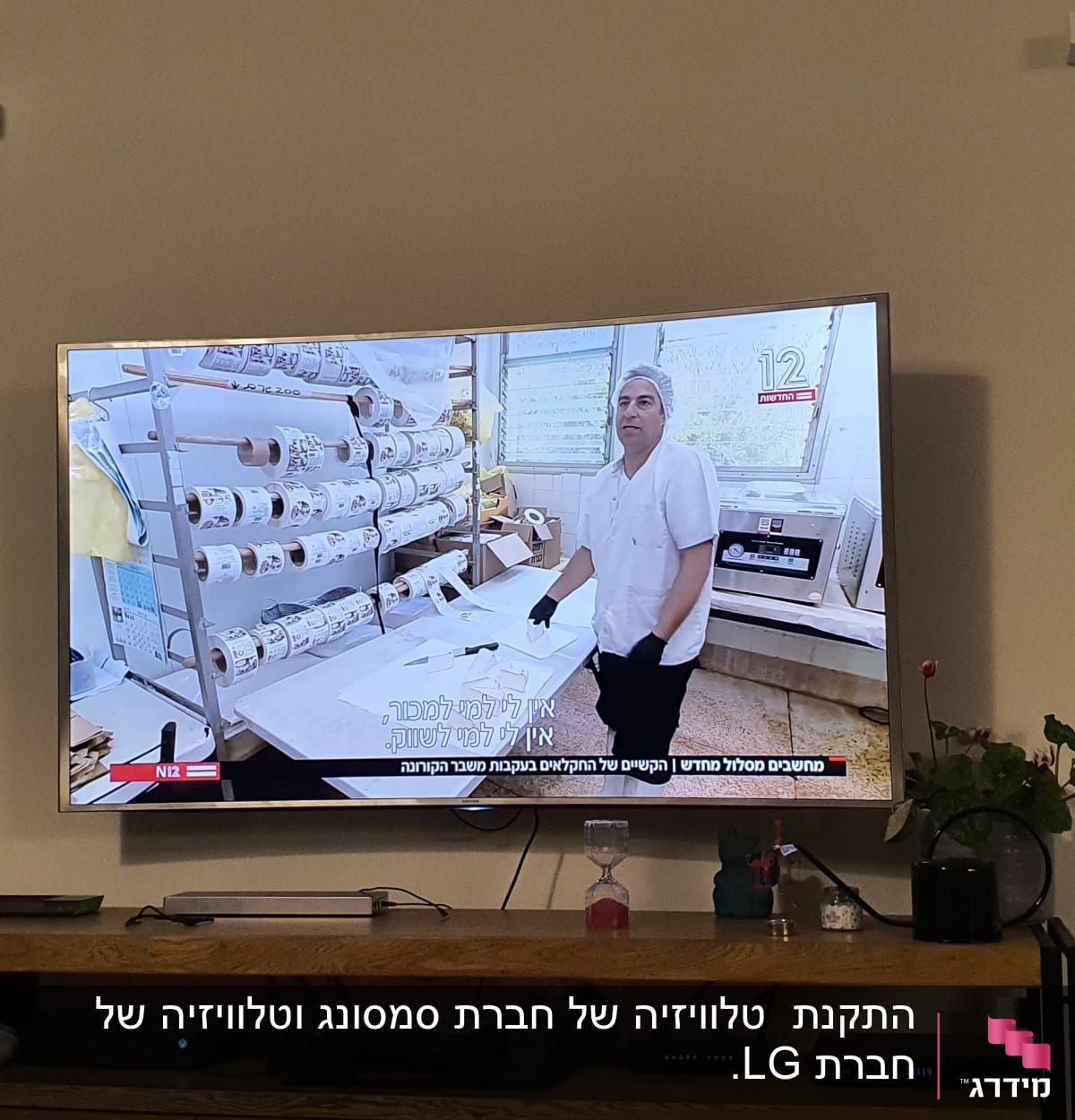 אדם עם כפפות ליד גלילי נייר במפעל
